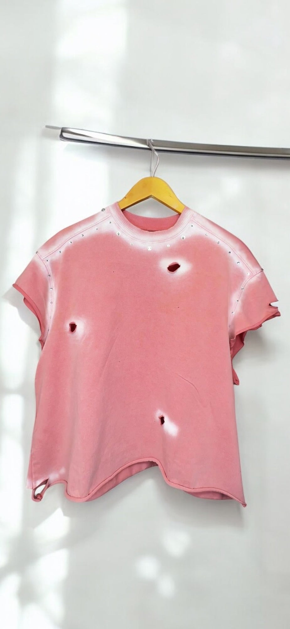 Pink and white sleeveless pullover with white designs and rhinestones