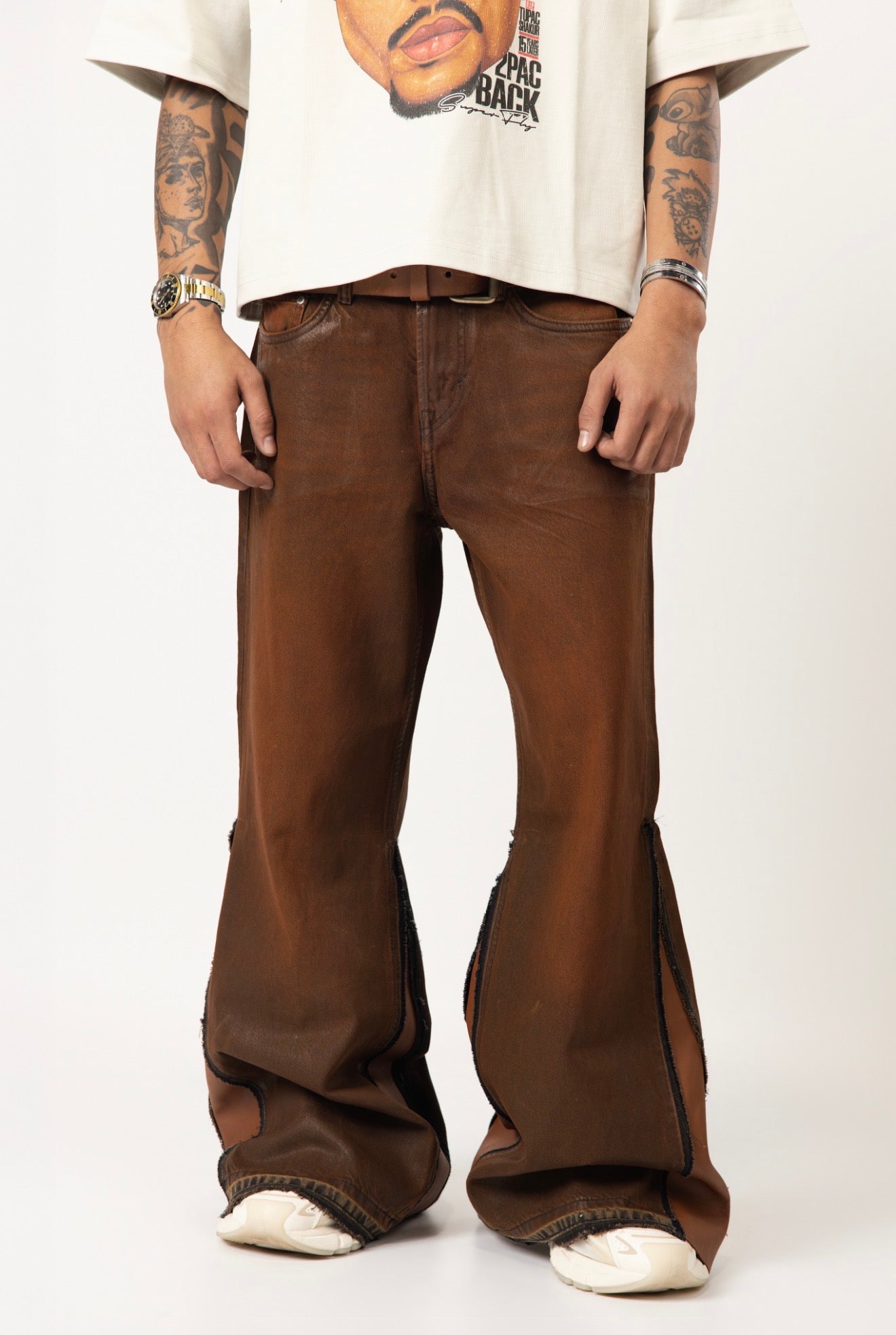 Brown wax-wash flare jeans with natural leather designs. ￼