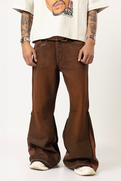 Brown wax-wash flare jeans with natural leather designs. ￼